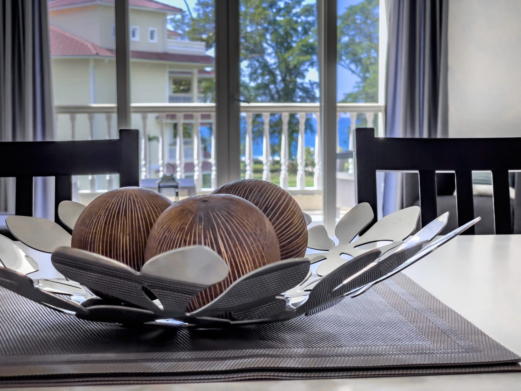 buyDRproperty Decorative bowl with wooden spheres on a dining table near a window. Sosua Real Estate
