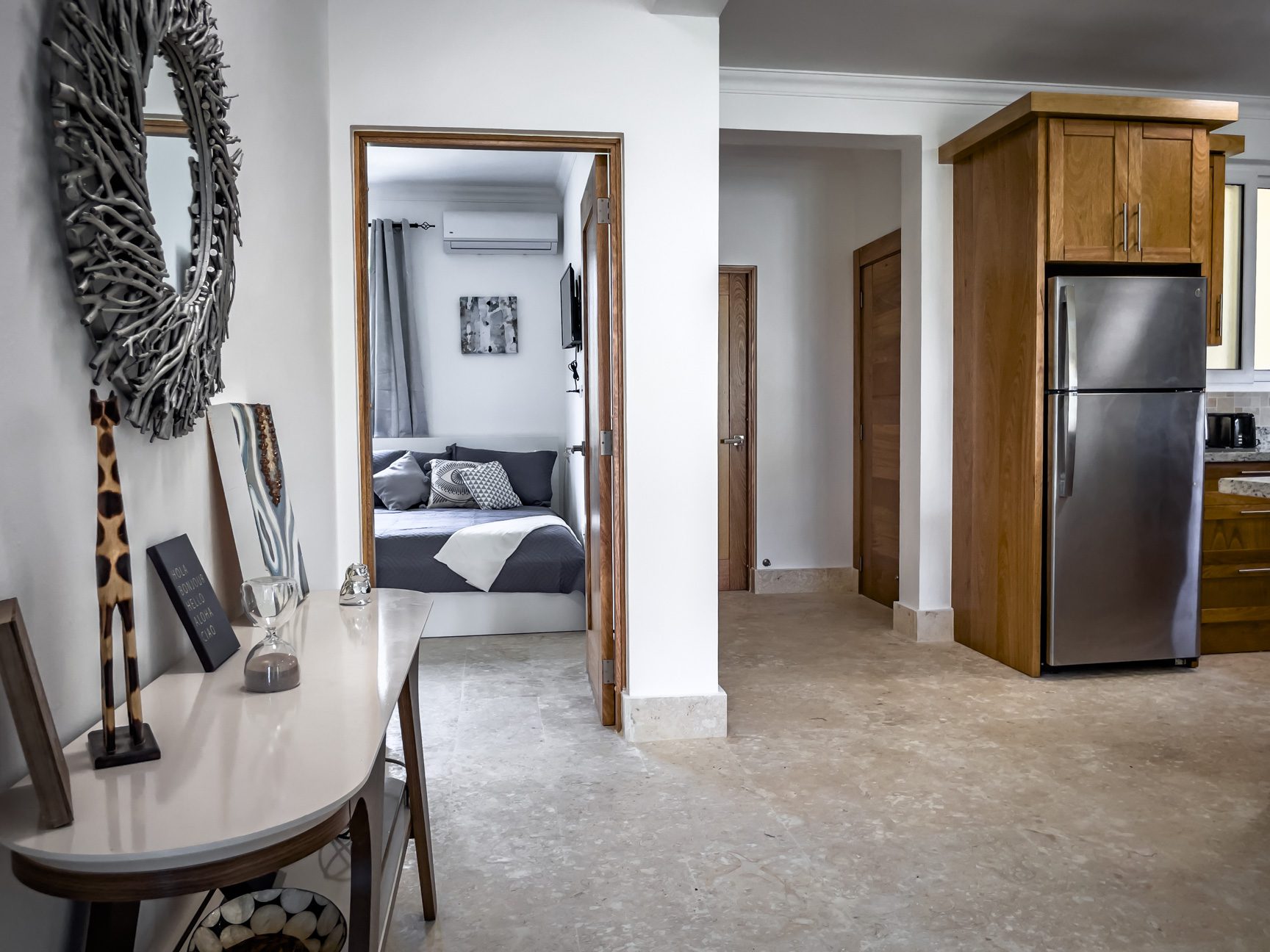 buyDRproperty Apartment interior: bedroom view from hallway, stainless steel fridge, modern decor. Sosua Real Estate