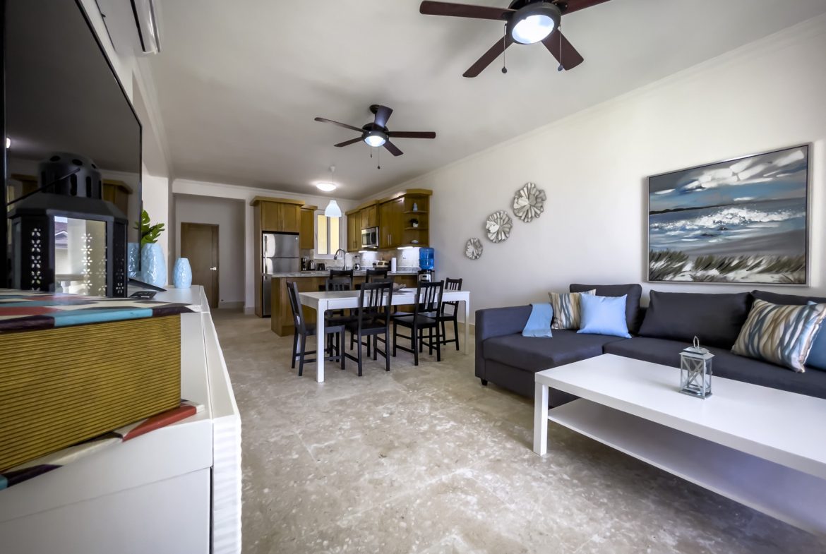 buyDRproperty Open-concept living room with kitchen, dining area, and comfortable seating, perfect for a relaxing vacation. Sosua Real Estate