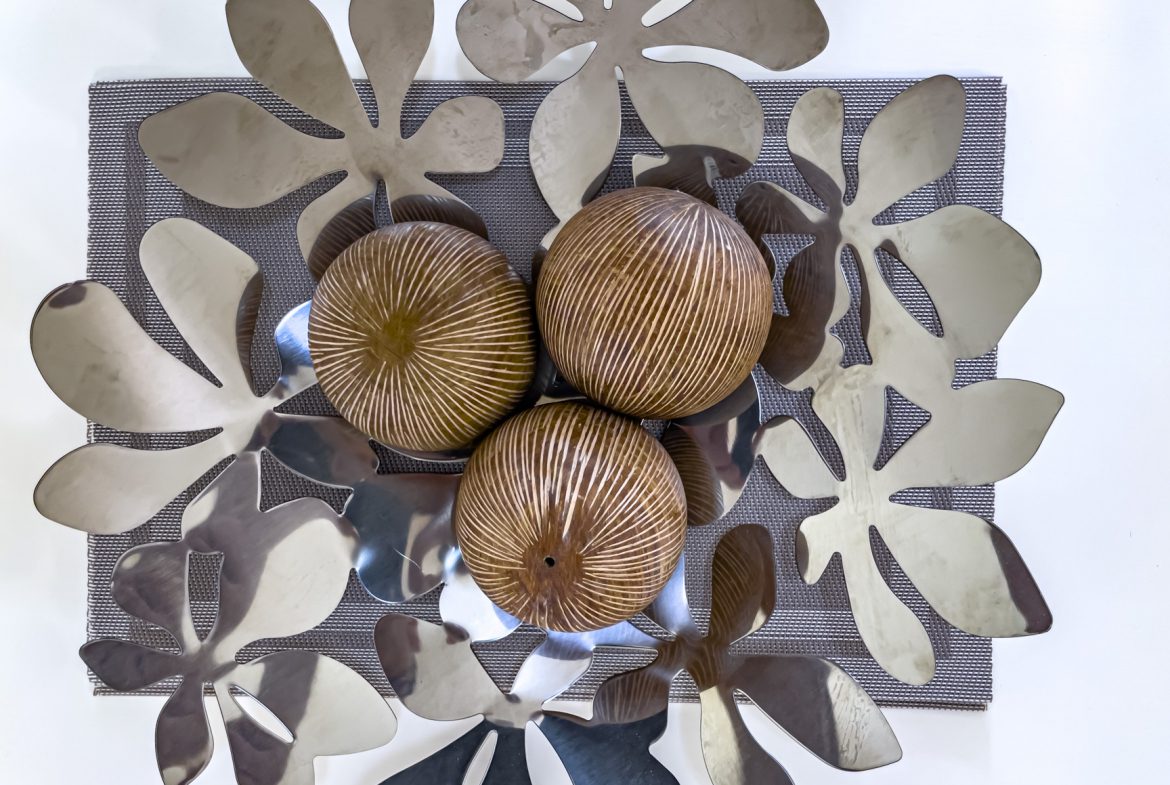 buyDRproperty Decorative centerpiece with brown striped spheres and silver flower accents on a gray placemat. Sosua Real Estate