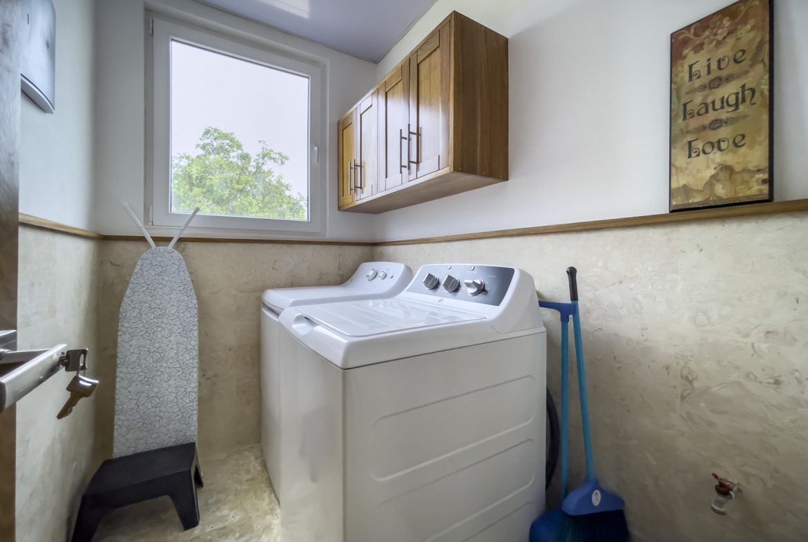 buyDRproperty Modern kitchen interior with stainless steel appliances and wooden cabinets. Sosua Real Estate