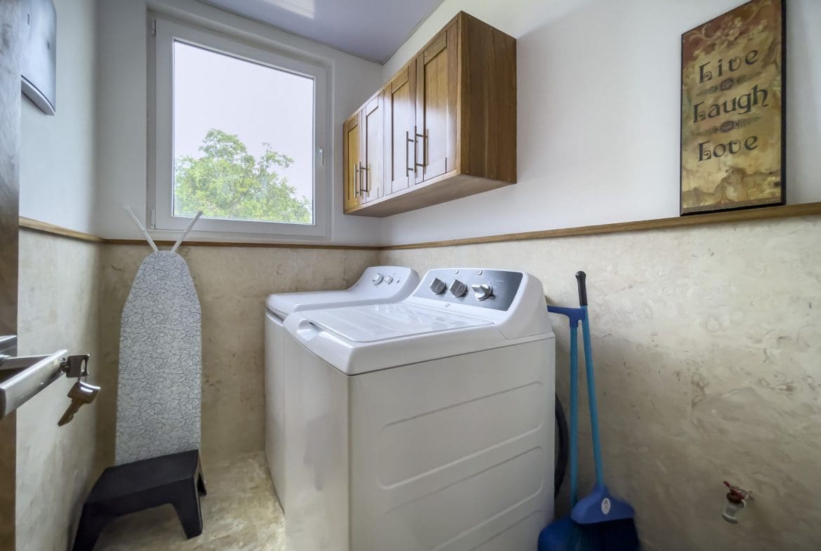 buyDRproperty Modern kitchen interior with stainless steel appliances and wooden cabinets. Sosua Real Estate