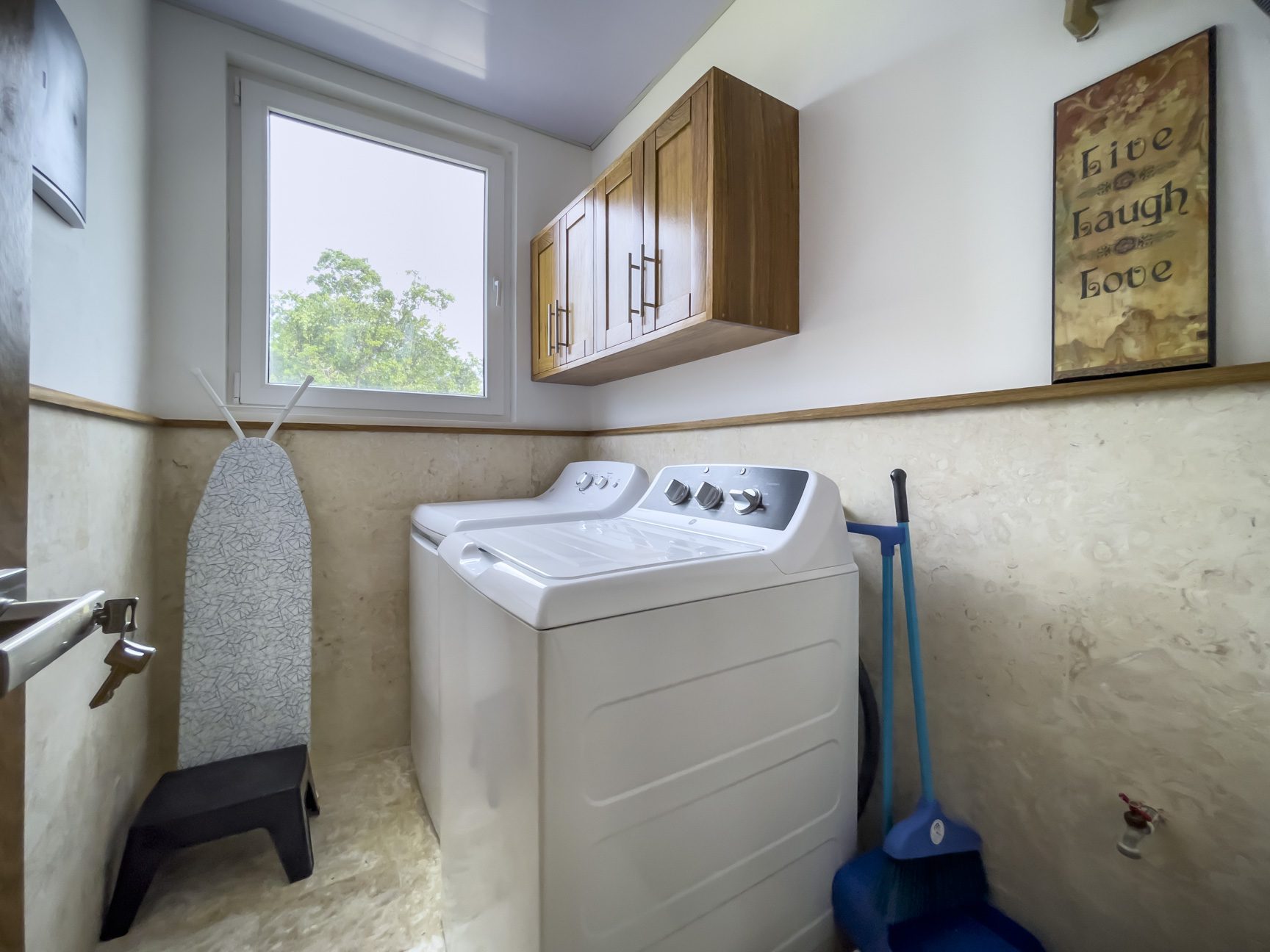 buyDRproperty Modern kitchen interior with stainless steel appliances and wooden cabinets. Sosua Real Estate