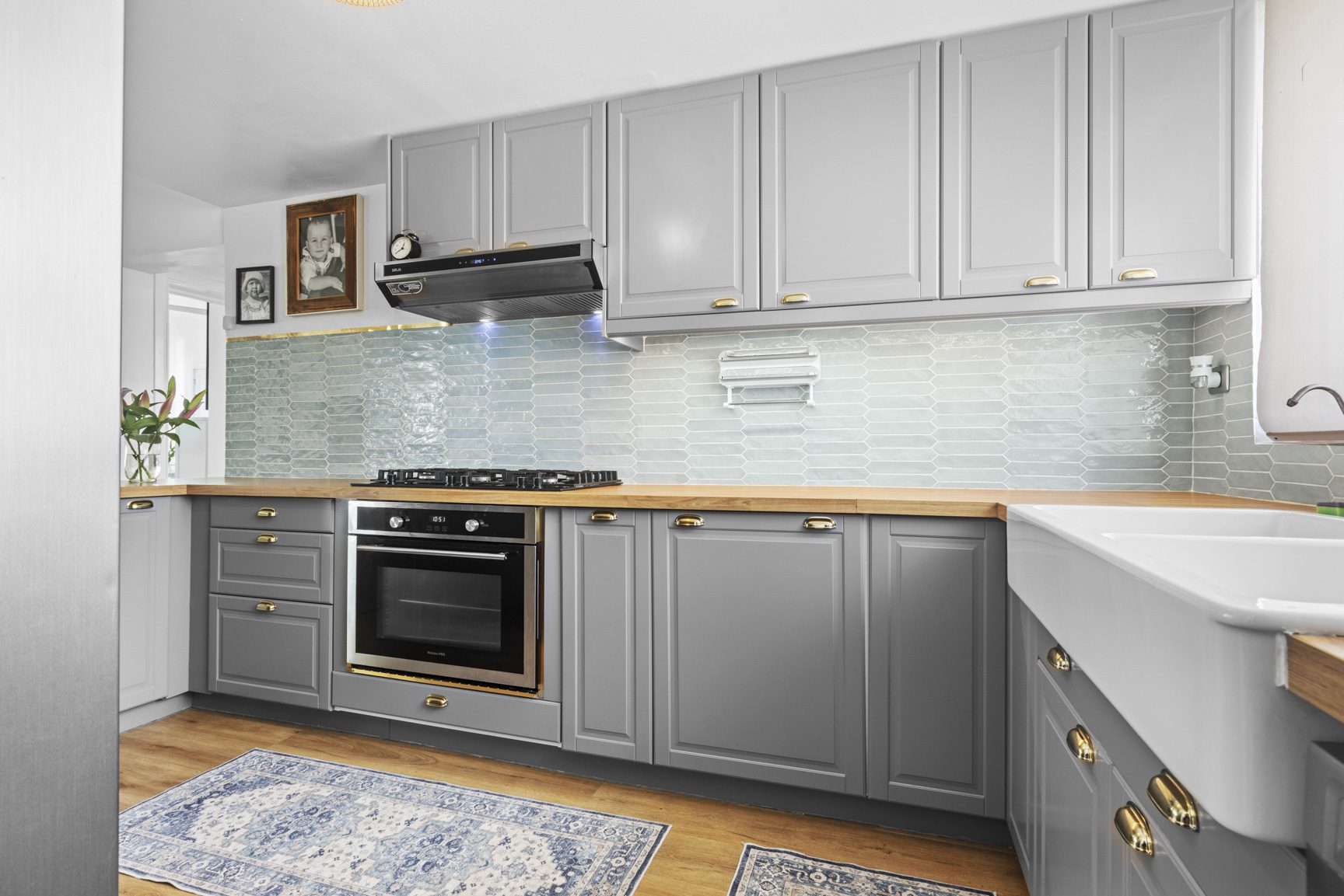buyDRproperty Gray kitchen with wood countertops, farmhouse sink, oven, and blue backsplash. Sosua Real Estate