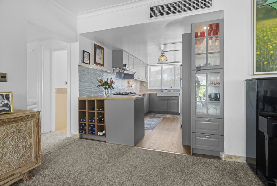 buyDRproperty Gray kitchen with wine rack, glass cabinets, and blue backsplash. Interior design. Sosua Real Estate