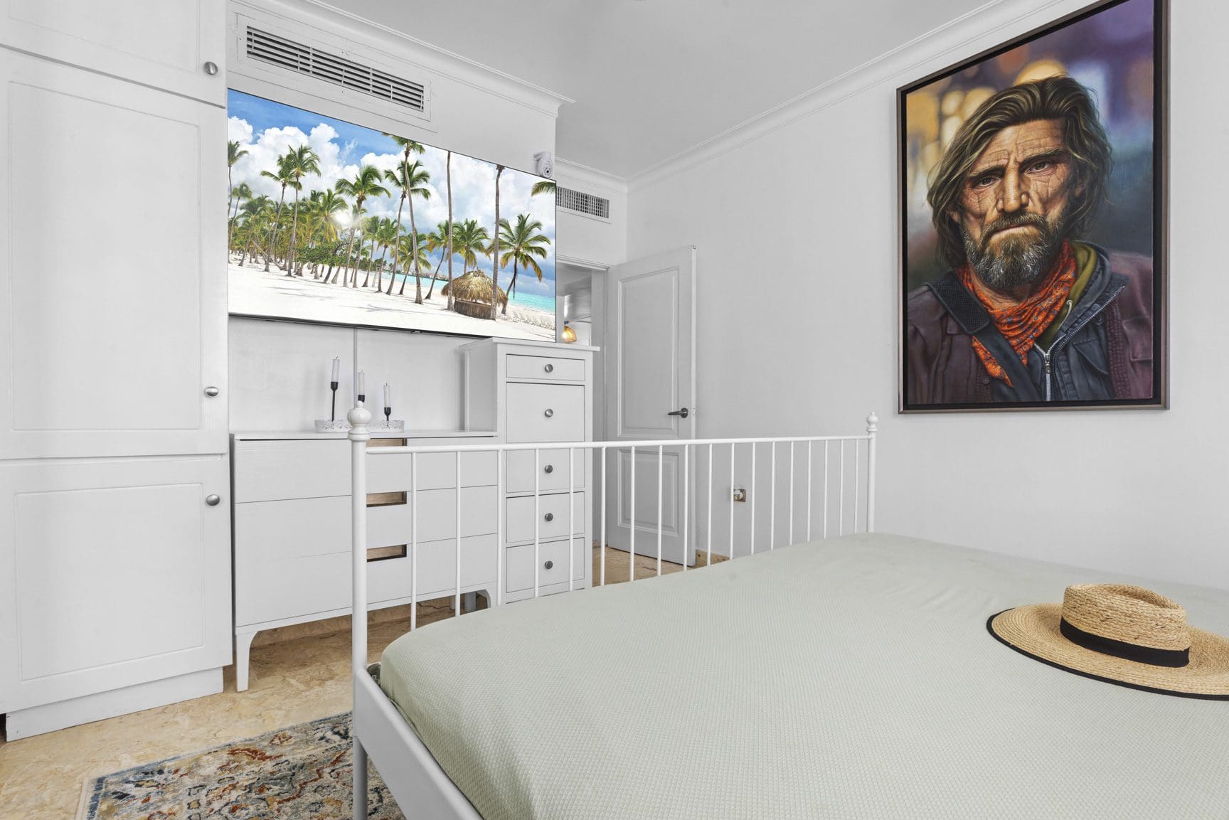buyDRproperty Bedroom with white furniture, bed, tropical wallpaper, and a hat on the bed Sosua Real Estate