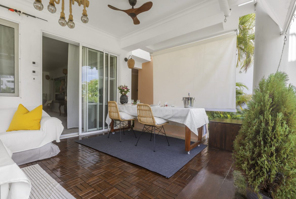 buyDRproperty Cozy outdoor dining area with table, chairs, and a lounge sofa. Sosua Real Estate