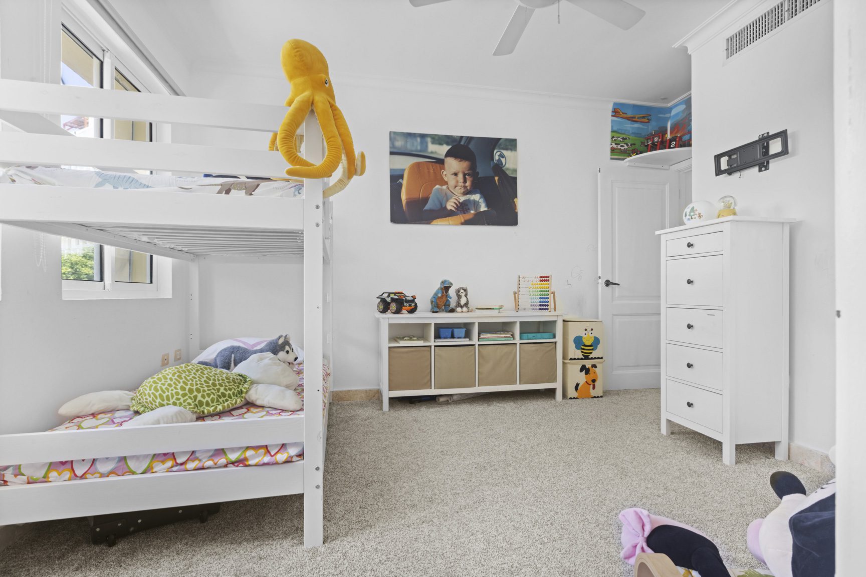 buyDRproperty White kids' room with bunk bed, toys, and a child's portrait. Sosua Real Estate