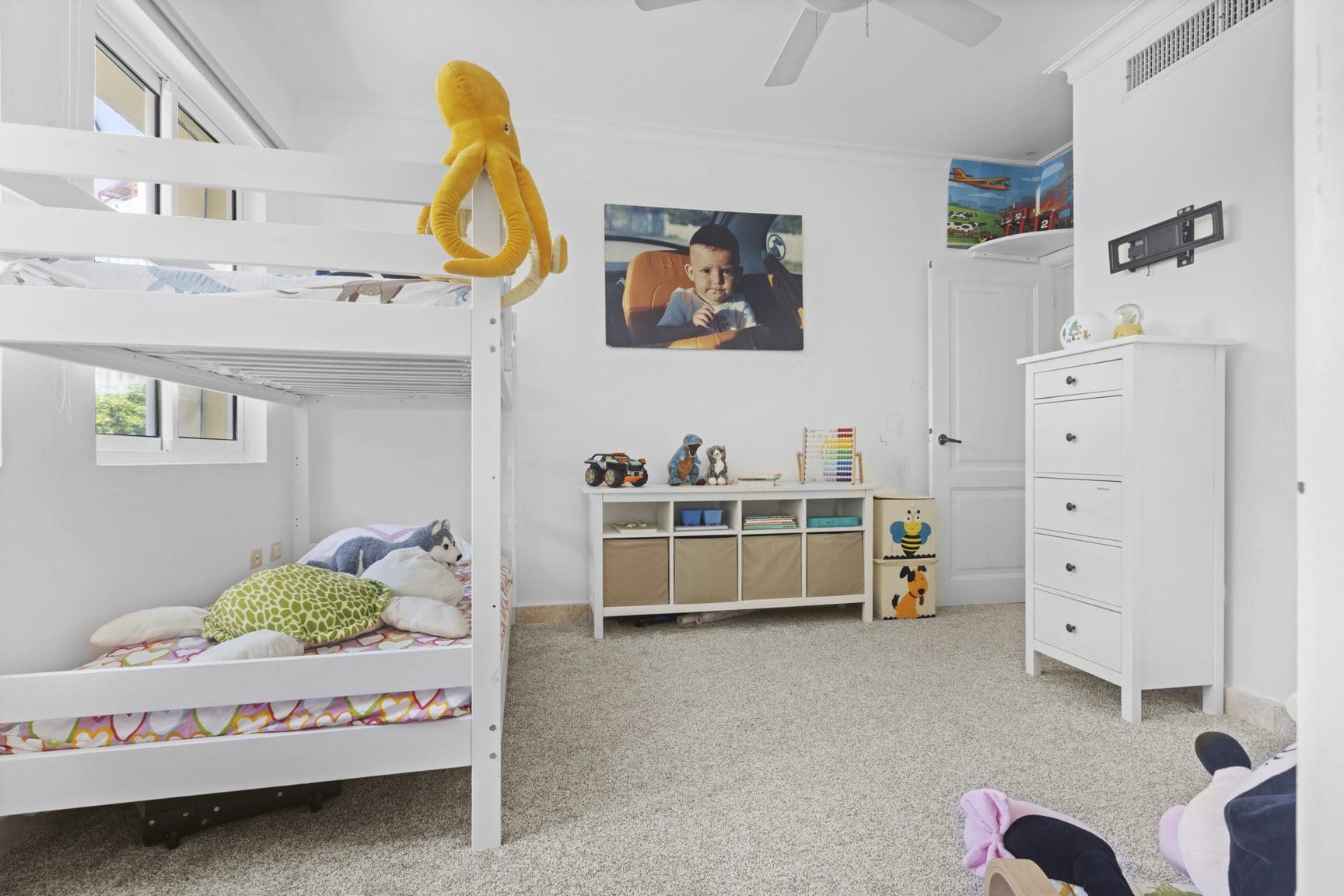 buyDRproperty White kids' room with bunk bed, toys, and a child's portrait. Sosua Real Estate