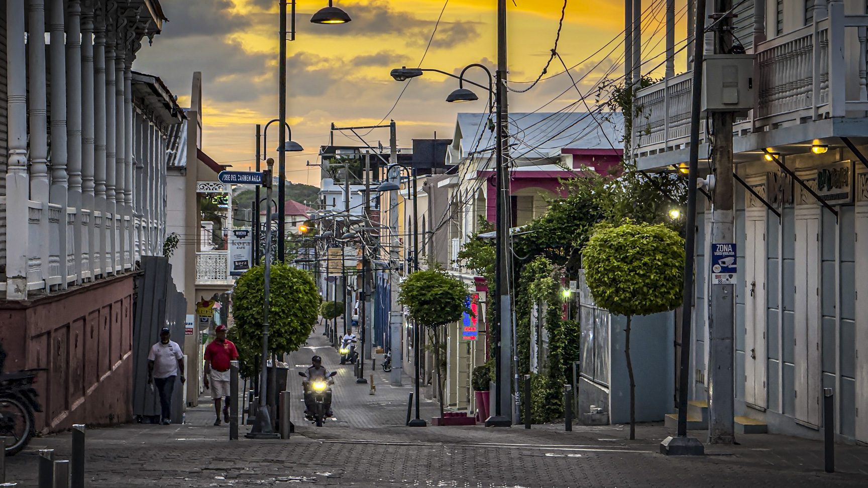 buyDRproperty Person reading book on bench in relaxing park setting. Sosua Real Estate