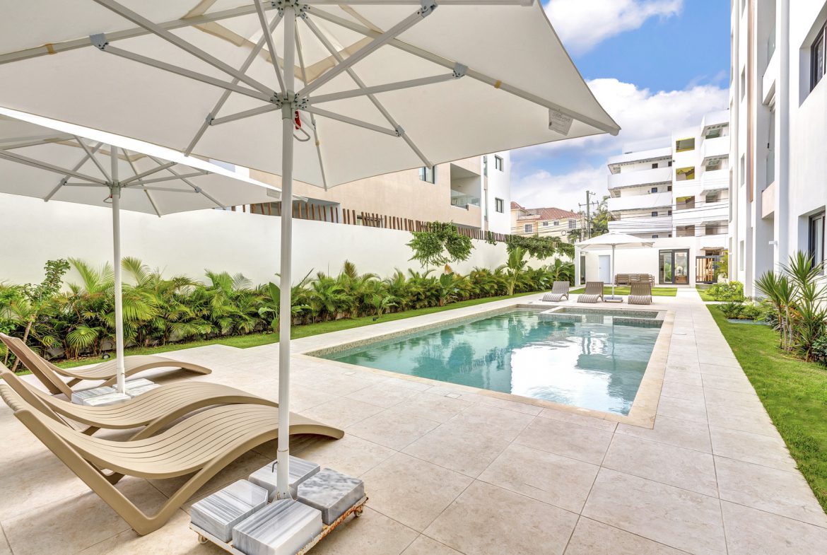 buyDRproperty Luxury pool area with lounge chairs and white umbrellas. Sosua Real Estate