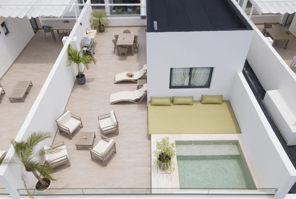 buyDRproperty Rooftop terrace with pool, lounge chairs, dining table, and modern outdoor furniture. Sosua Real Estate