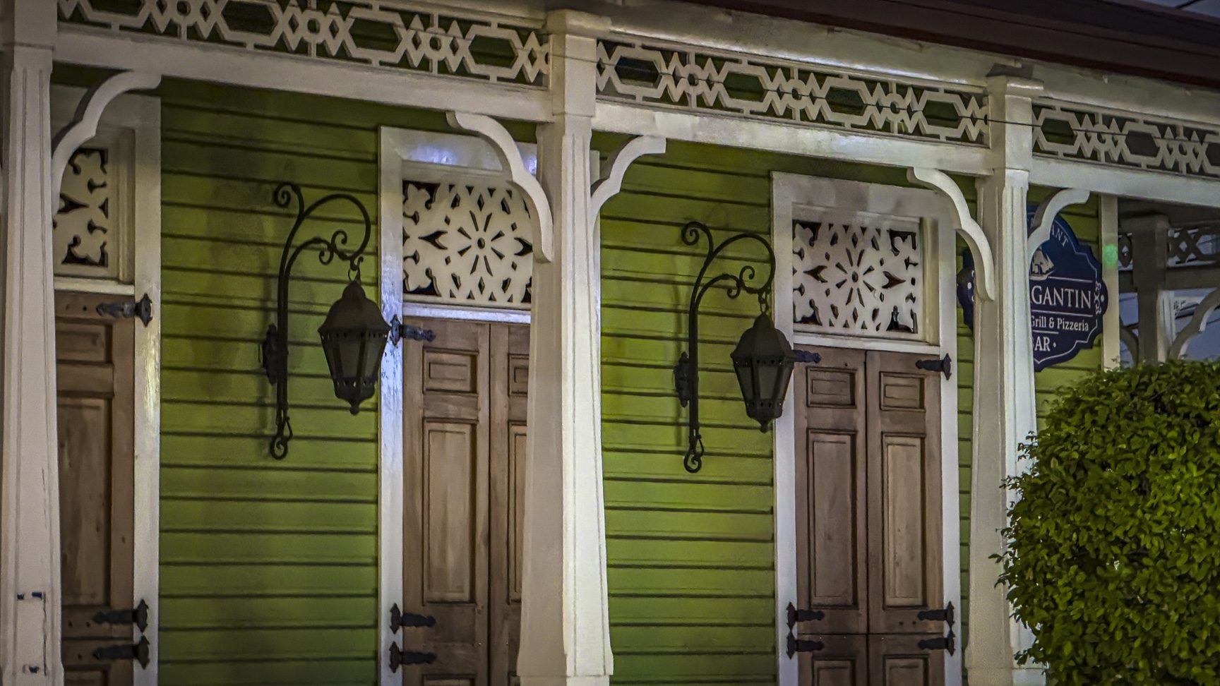 buyDRproperty Green building facade with ornate wooden doors and decorative lanterns. Sosua Real Estate