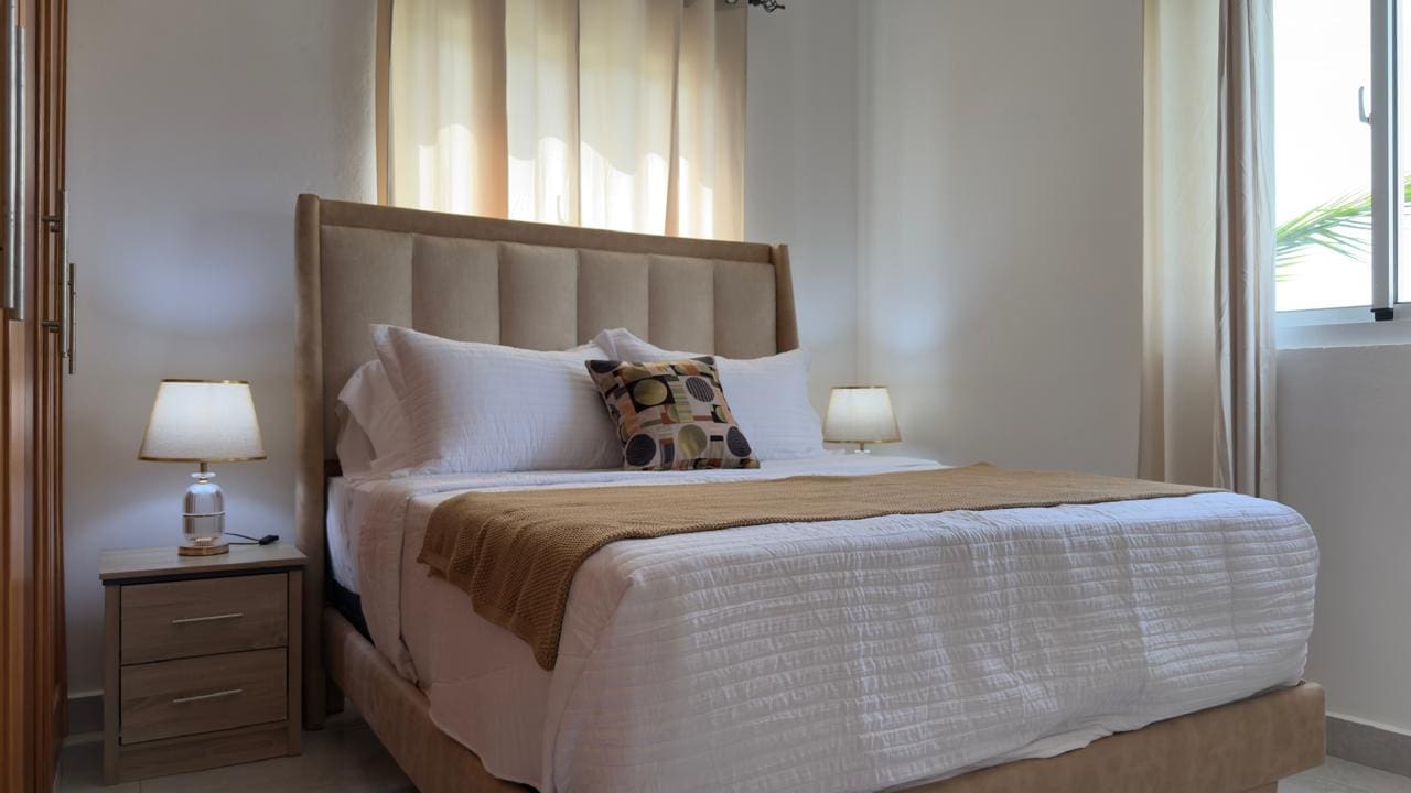 buyDRproperty Cozy bedroom with a king-size bed, white linens, and neutral decor. Sosua Real Estate