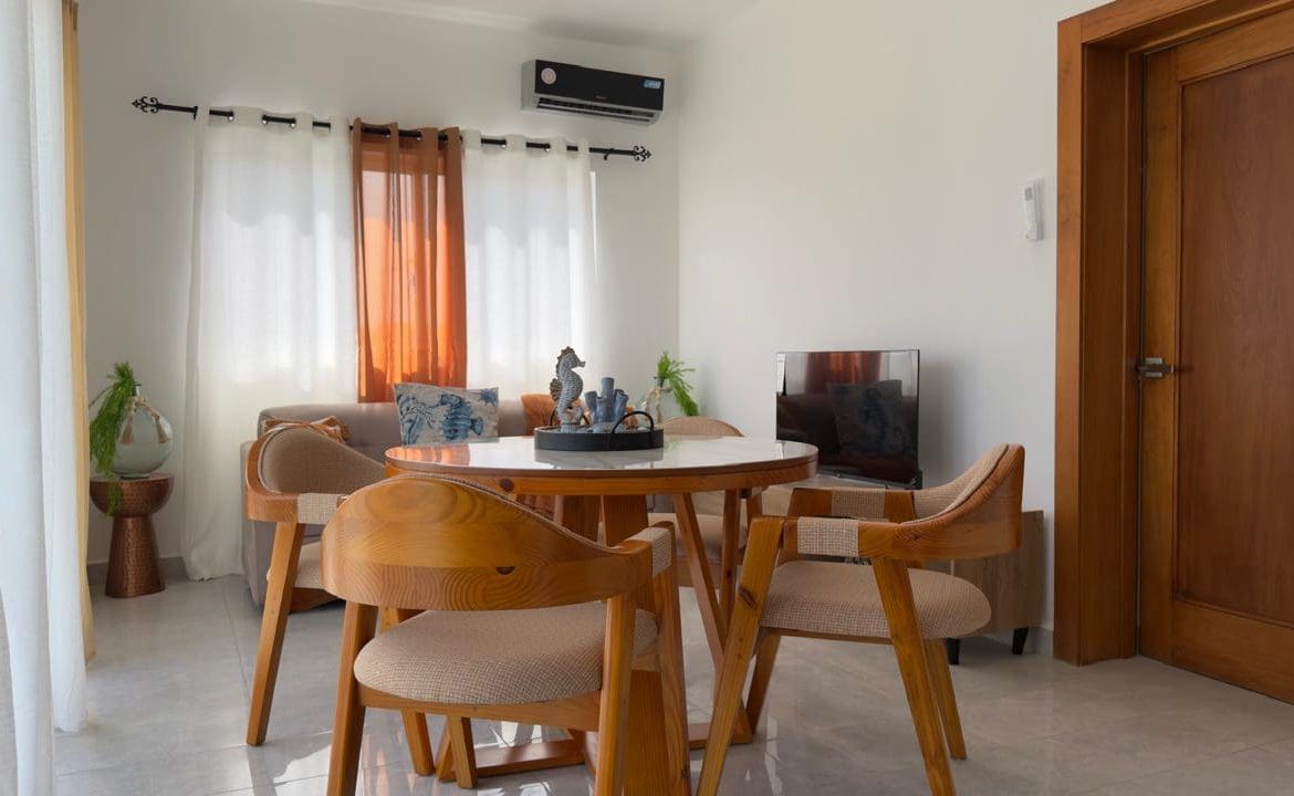 buyDRproperty Cozy living room interior with round dining table and modern decor. Sosua Real Estate