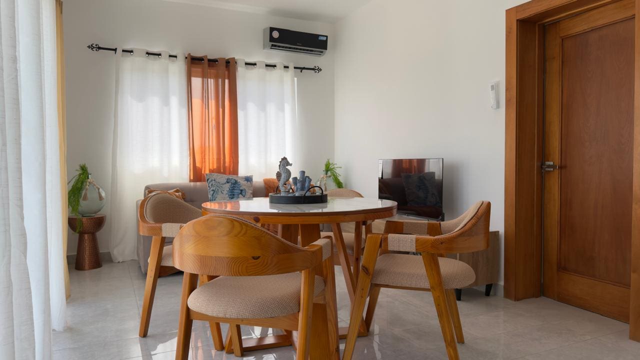 buyDRproperty Cozy living room interior with round dining table and modern decor. Sosua Real Estate