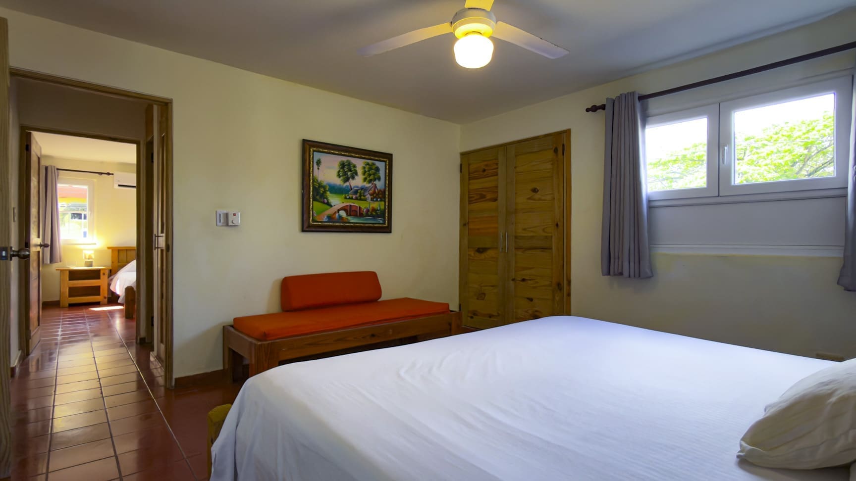 buyDRproperty Cozy bedroom with a large bed, wooden wardrobe, and a colorful painting. Sosua Real Estate
