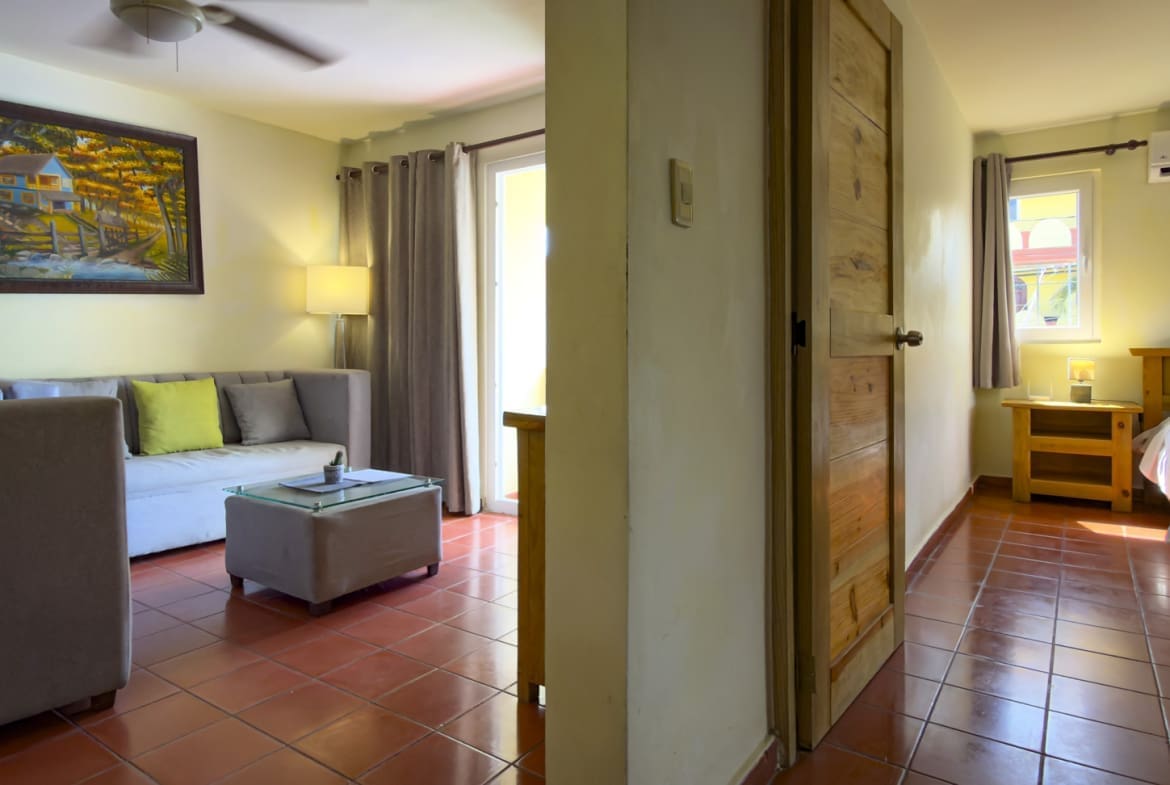 buyDRproperty Living room with sofa, coffee table, and entryway to a bedroom with a bed Sosua Real Estate