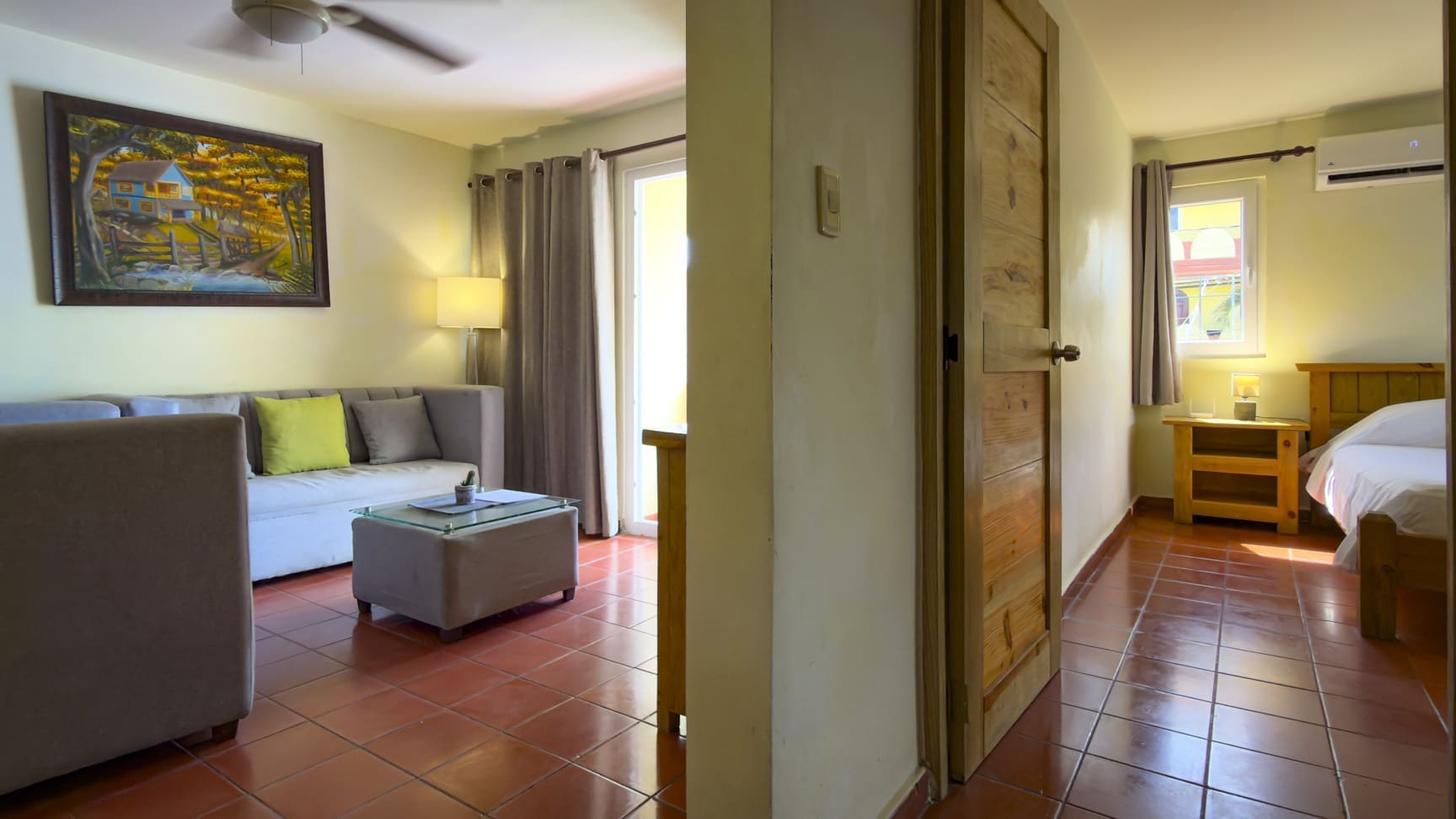 buyDRproperty Living room with sofa, coffee table, and entryway to a bedroom with a bed Sosua Real Estate