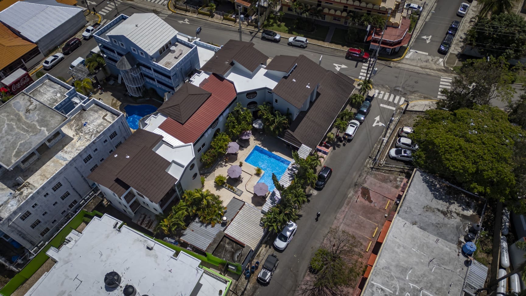 buyDRproperty Aerial view of a resort with a pool, palm trees, and surrounding buildings. Sosua Real Estate