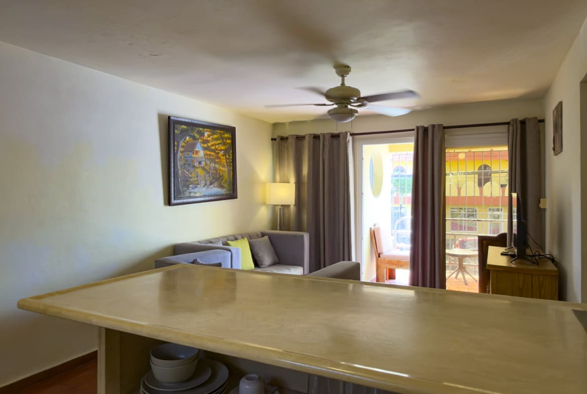 buyDRproperty Bright living room with sofa, ceiling fan, and balcony view. Sosua Real Estate