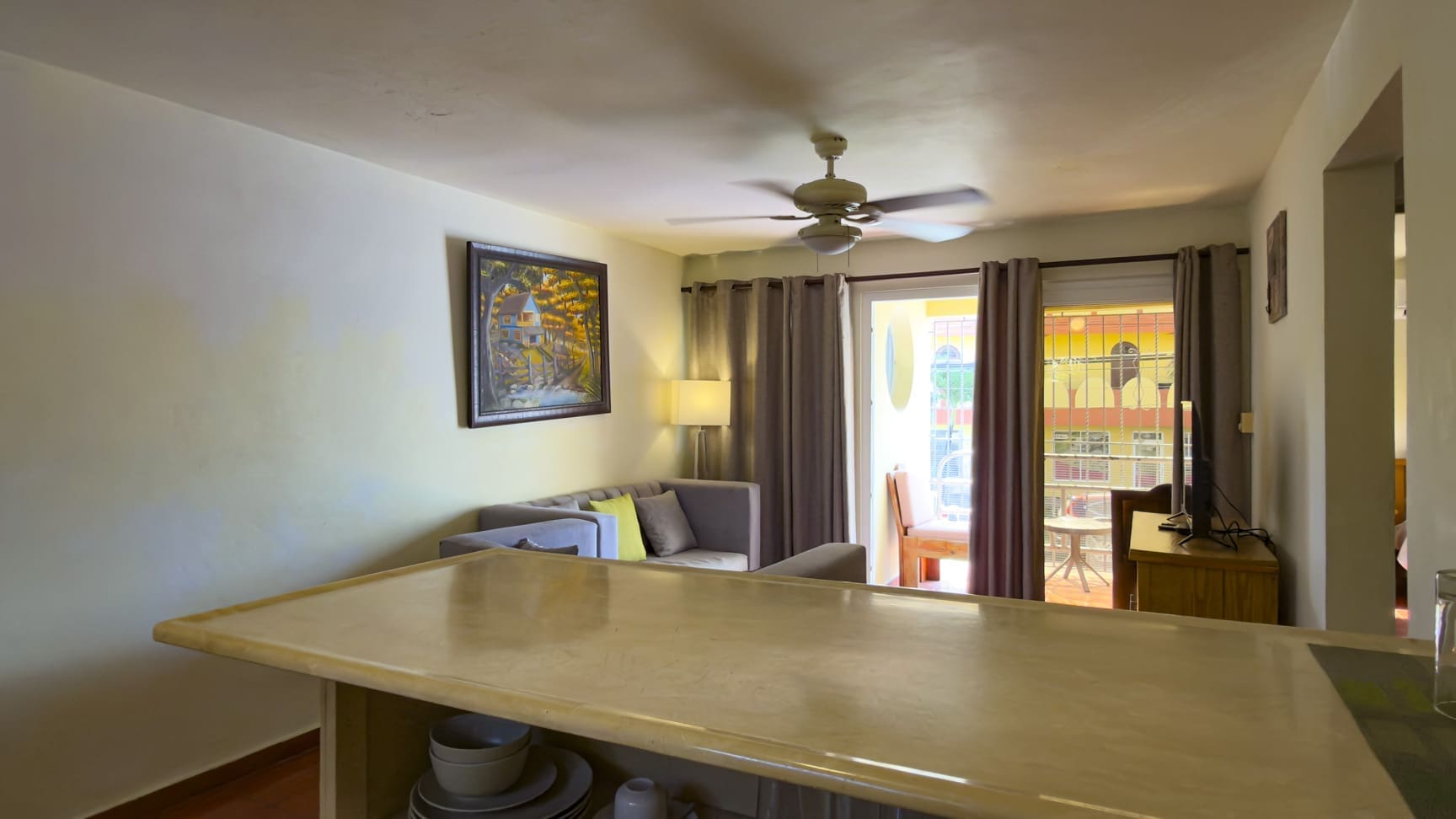 buyDRproperty Bright living room with sofa, ceiling fan, and balcony view. Sosua Real Estate