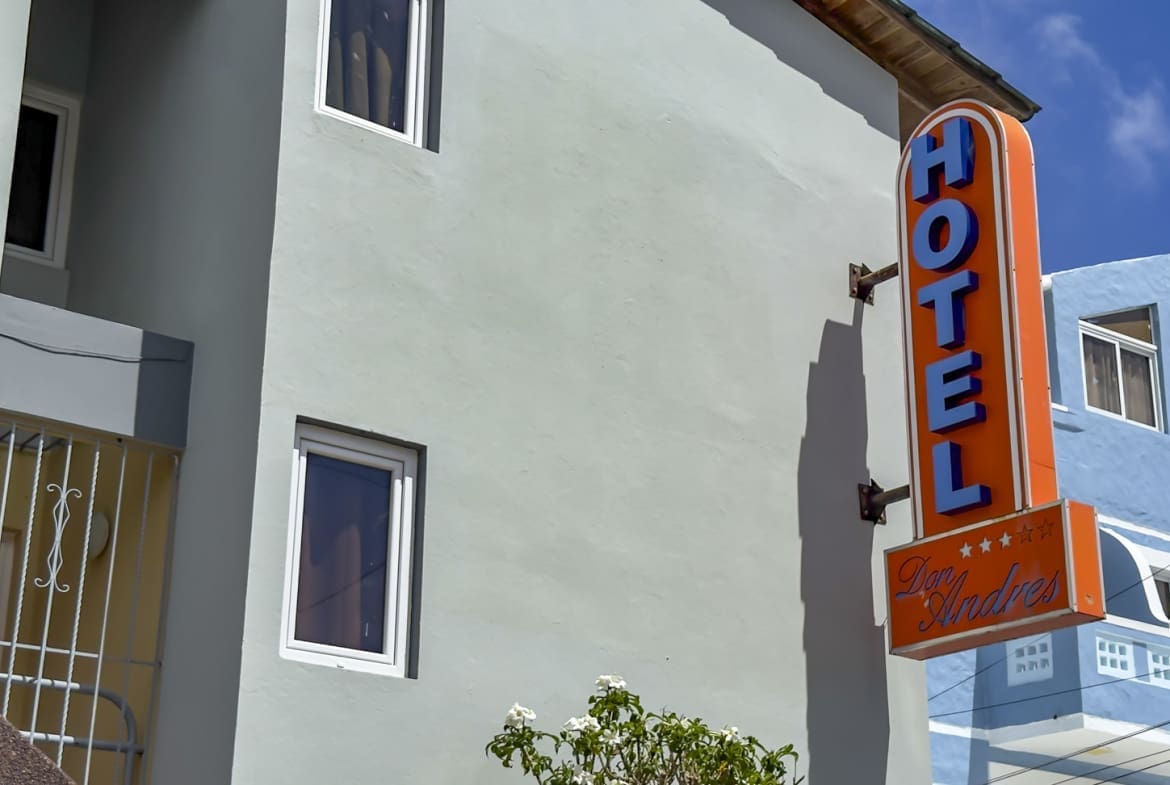 buyDRproperty Orange "HOTEL Don Andres" sign on a light blue building Sosua Real Estate