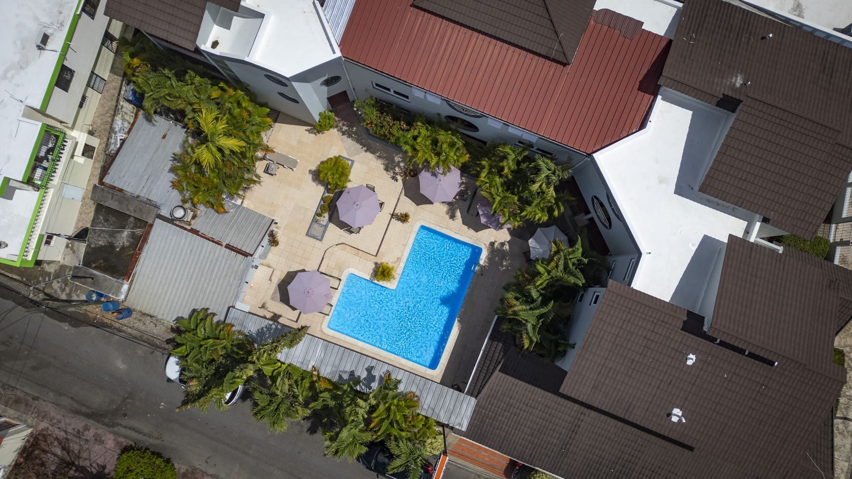 buyDRproperty Aerial view of a resort pool with lounge chairs and palm trees. Sosua Real Estate