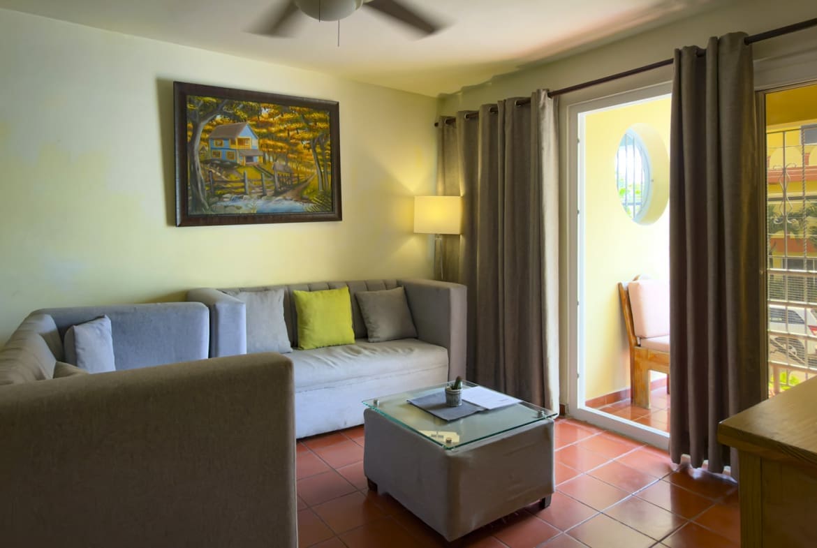 buyDRproperty Cozy living room with sectional sofa, coffee table, and balcony door Sosua Real Estate