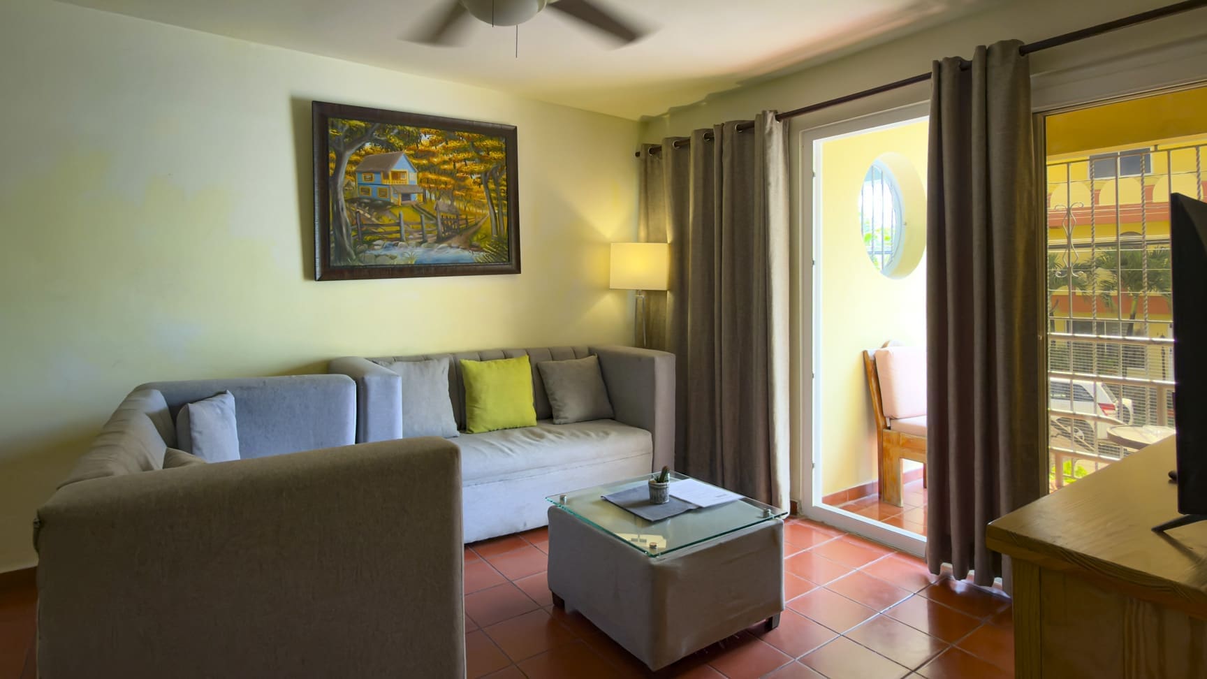 buyDRproperty Cozy living room with sectional sofa, coffee table, and balcony door Sosua Real Estate