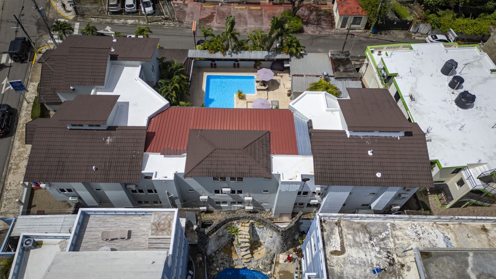 buyDRproperty Aerial view of a hotel complex with a blue pool and brown rooftops. Sosua Real Estate
