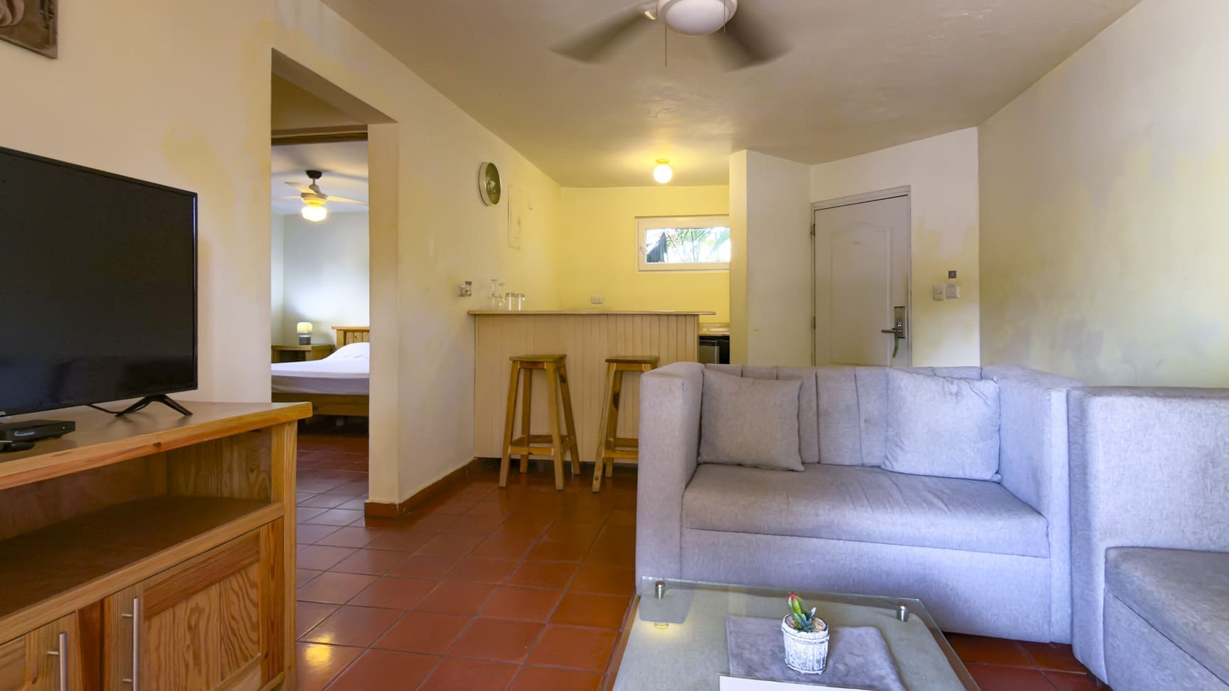 buyDRproperty Living room with gray sofa, bar, and view of bedroom Sosua Real Estate