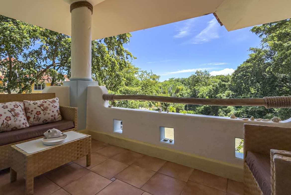 buyDRproperty Balcony with wicker furniture and tropical foliage view Sosua Real Estate