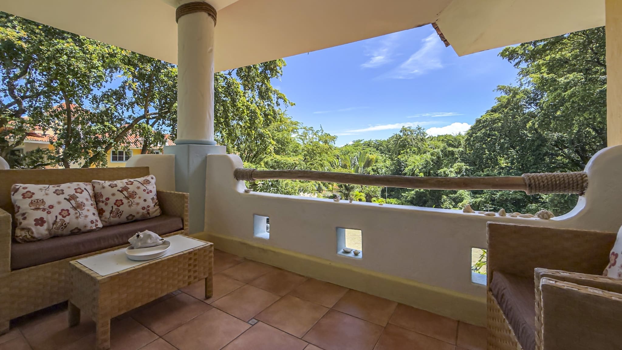 buyDRproperty Balcony with wicker furniture and tropical foliage view Sosua Real Estate