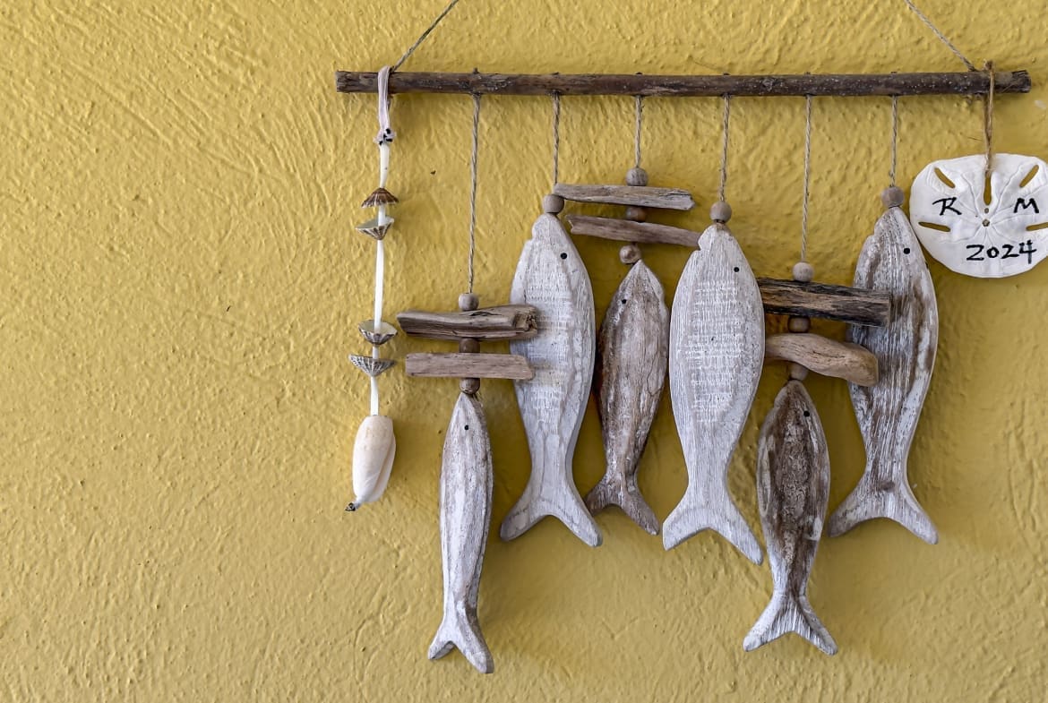 buyDRproperty Handmade wooden fish mobile with shells and sand dollar on yellow wall Sosua Real Estate