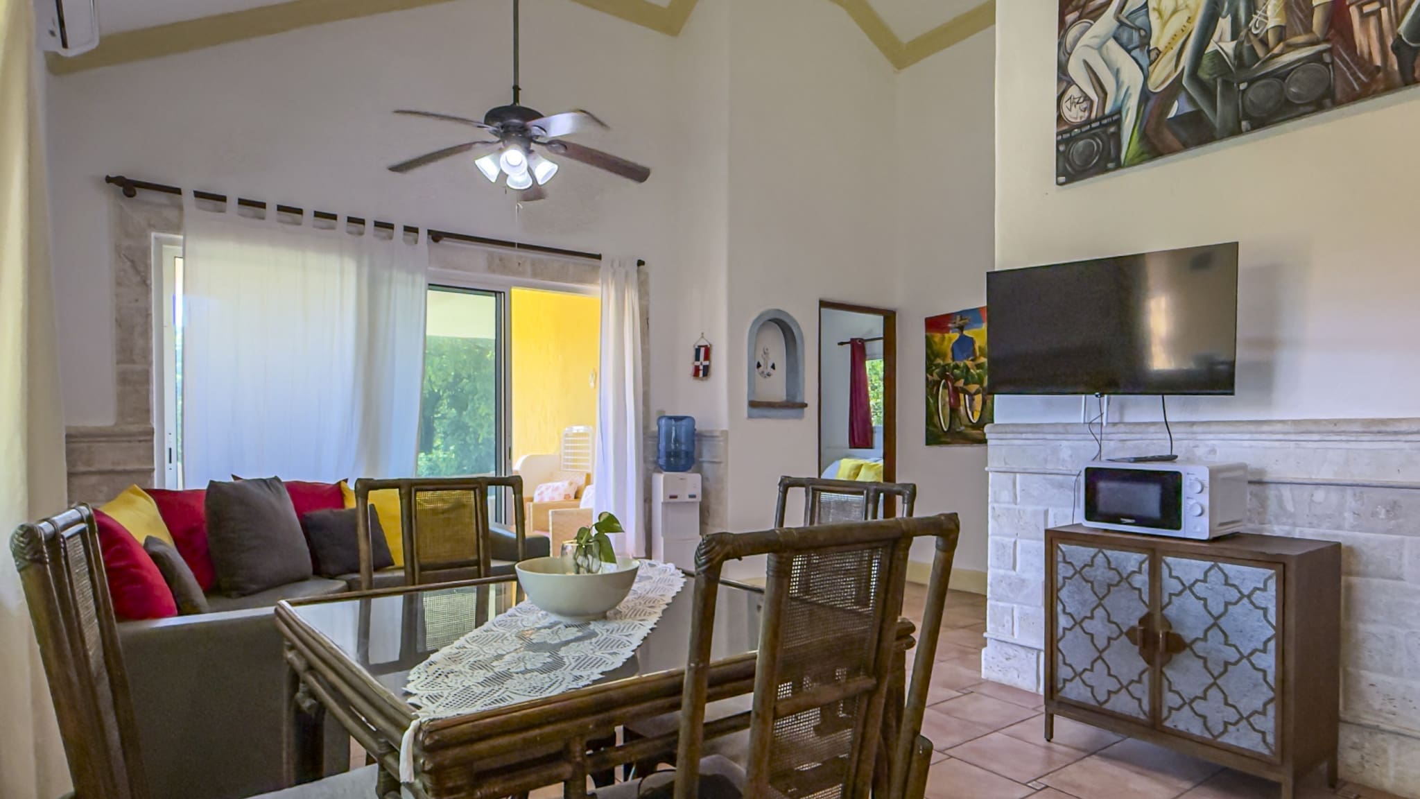buyDRproperty Dining area with rattan chairs and table, living room with sofa, and TV. Sosua Real Estate