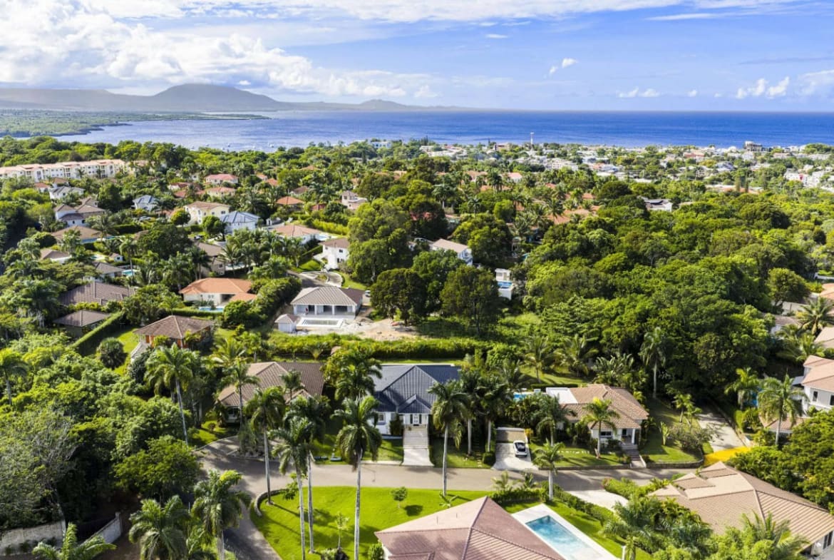 buyDRproperty Aerial view of luxury villas and lush tropical foliage in a coastal community. Sosua Real Estate