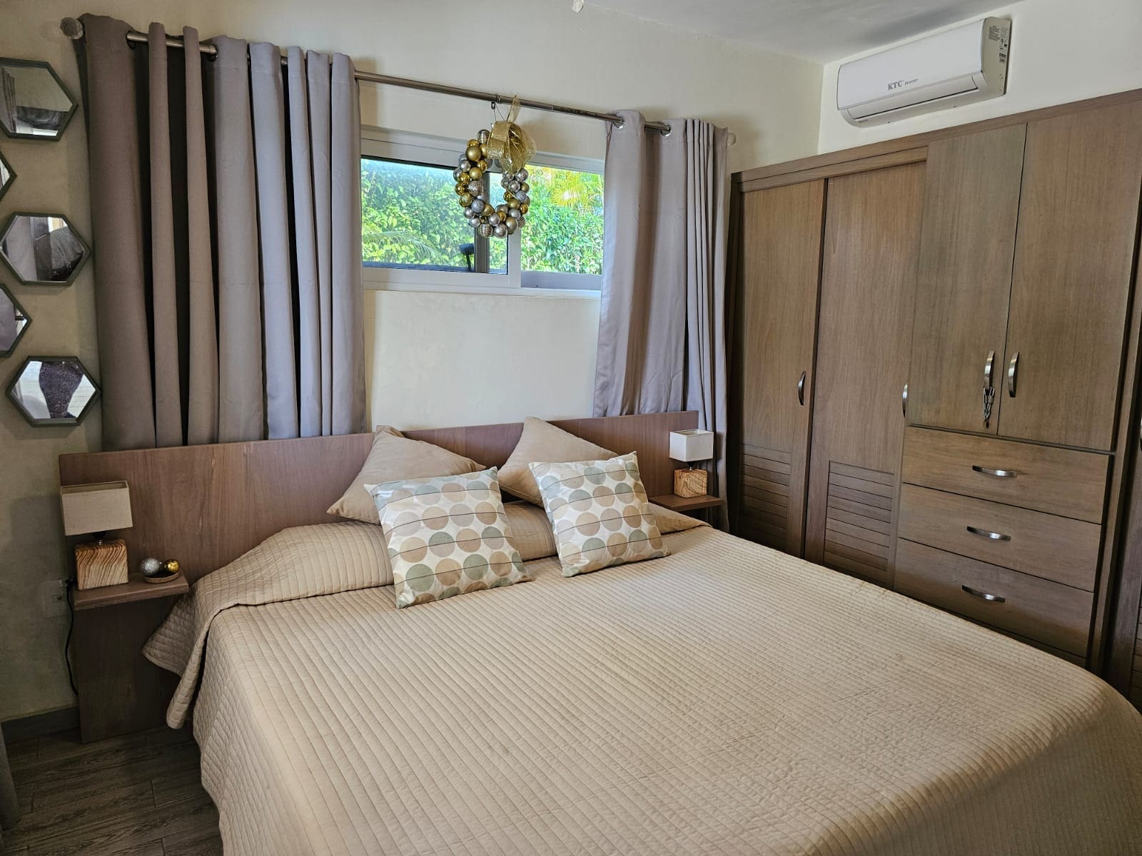 buyDRproperty Cozy bedroom with a queen-size bed, wooden wardrobe, and window decor. Sosua Real Estate