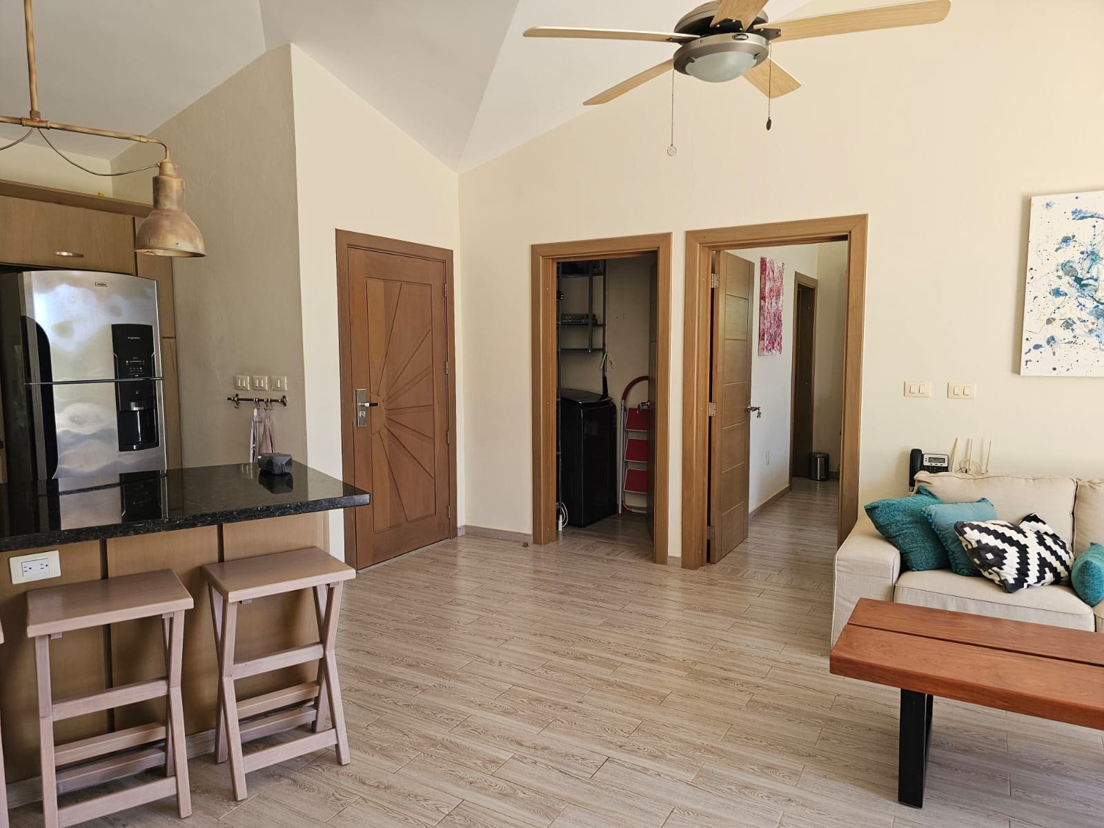 buyDRproperty Modern kitchen with island, stools, and living area with sofa and coffee table Sosua Real Estate