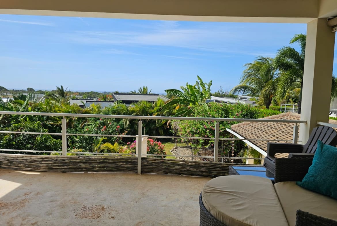 buyDRproperty Balcony view of lush tropical foliage and ocean horizon. Sosua Real Estate