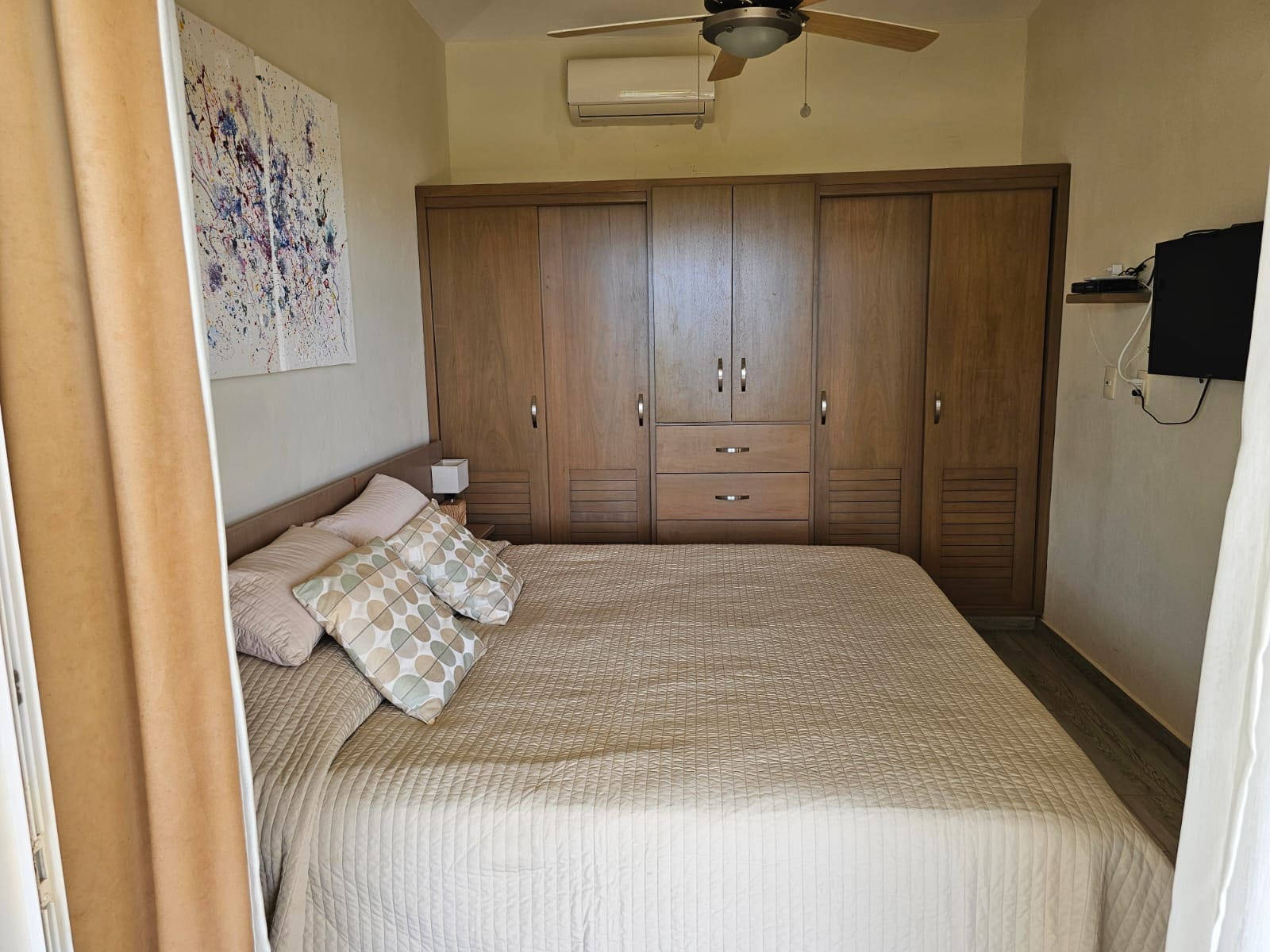 buyDRproperty Spacious bedroom with a large wooden wardrobe and a queen-size bed. Sosua Real Estate