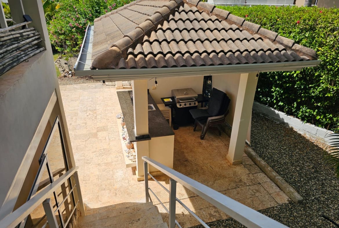 buyDRproperty Outdoor kitchen with grill and bar under a tiled roof, perfect for entertaining. Sosua Real Estate
