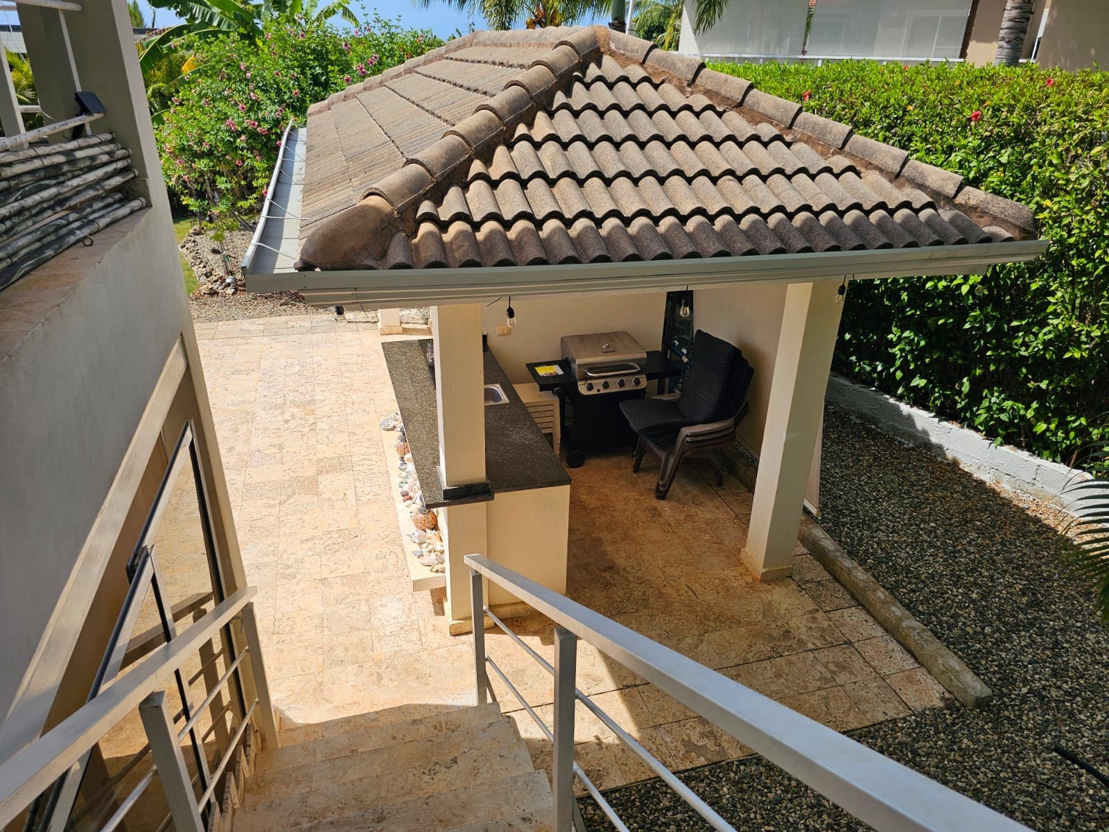 buyDRproperty Outdoor kitchen with grill and bar under a tiled roof, perfect for entertaining. Sosua Real Estate