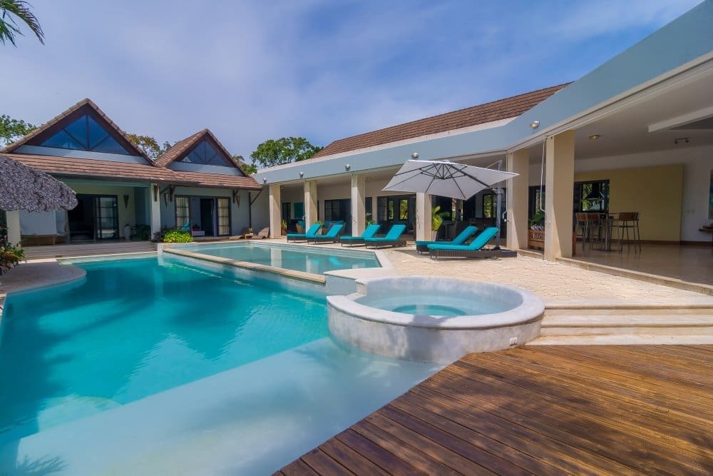 buyDRproperty Luxury villa with pool, jacuzzi, and lounge chairs in a tropical setting. Sosua Real Estate