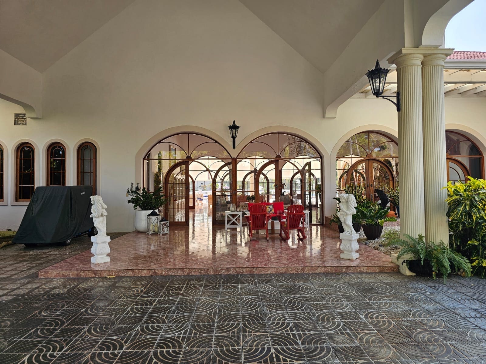 buyDRproperty Elegant arched doorways and windows of a covered patio with outdoor seating. Sosua Real Estate