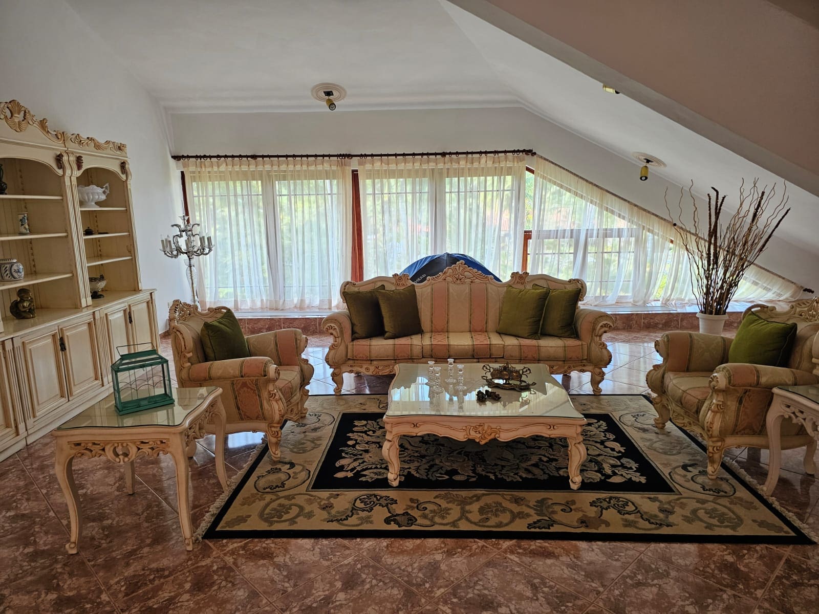 buyDRproperty Elegant living room with ornate furniture, plush seating, and large windows. Sosua Real Estate