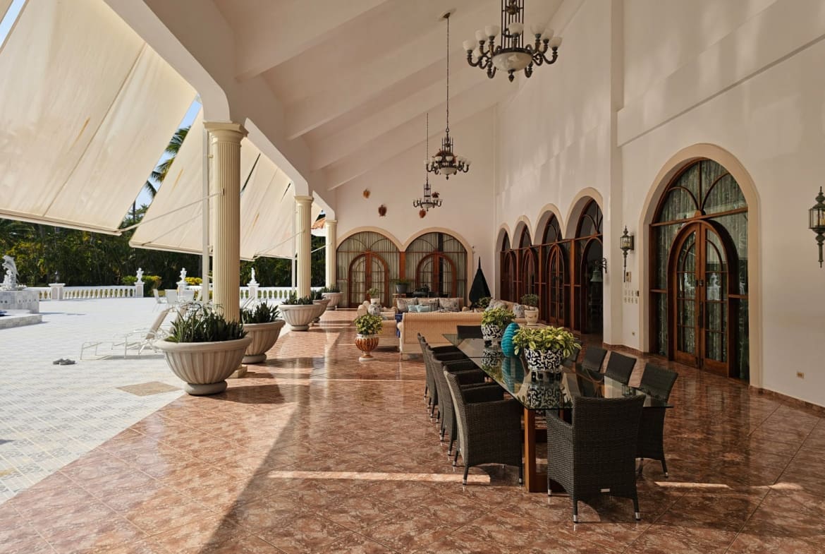 buyDRproperty Spacious covered patio with dining table, chairs, and arched windows Sosua Real Estate