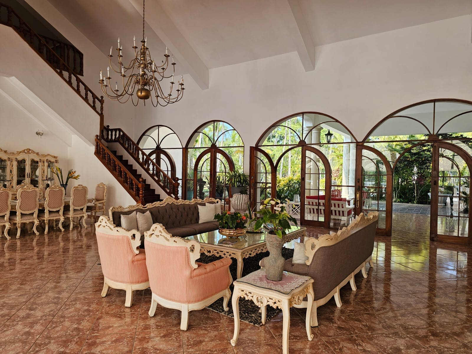 buyDRproperty Luxurious living room with arched windows, ornate furniture, and a grand staircase. Sosua Real Estate