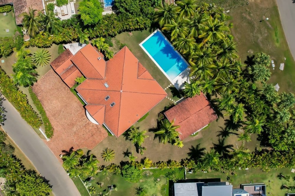 buyDRproperty Aerial view of a luxurious villa with a swimming pool surrounded by palm trees. Sosua Real Estate