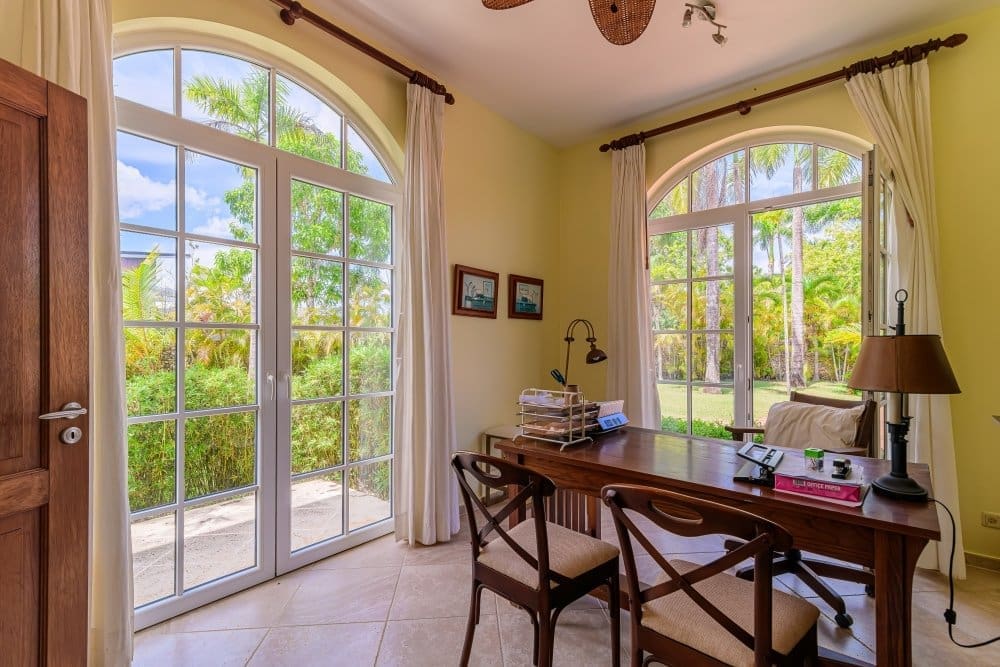 buyDRproperty Home office with large arched windows overlooking a tropical garden Sosua Real Estate